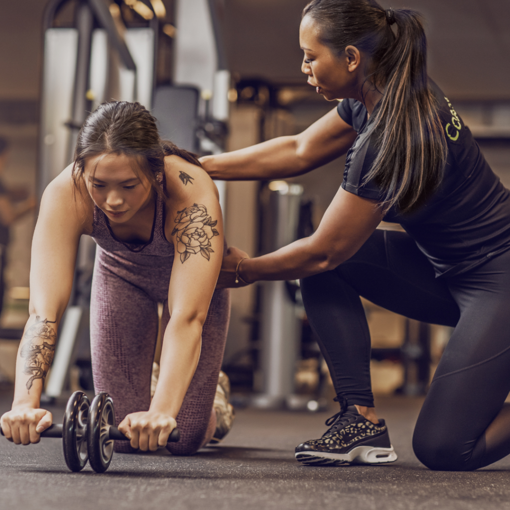 a personal trainer is helping a client with an exercise in a gym