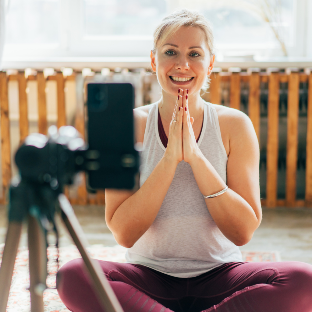 a yoga instructor teaching an online yoga class in front of a camera