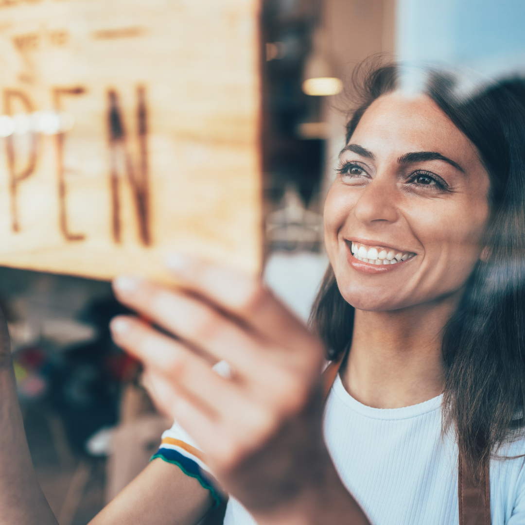 Business owner hanging an open sign