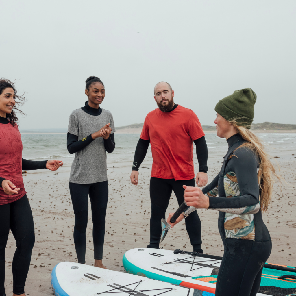 Paddle board yoga instructor giving directions to participants