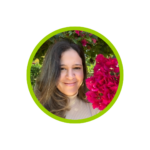 Elisa Calosso in brown shirt with hair to one side, smiling with no teeth with a background of pink flower tree