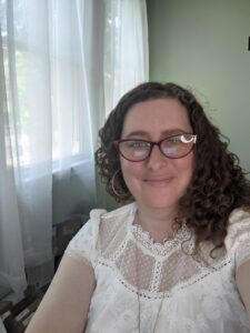 headshot of Rebecca Sebastian, smiling in white shirt